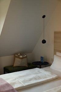 Zimmer-Detail — Bett und Nachttischlampe