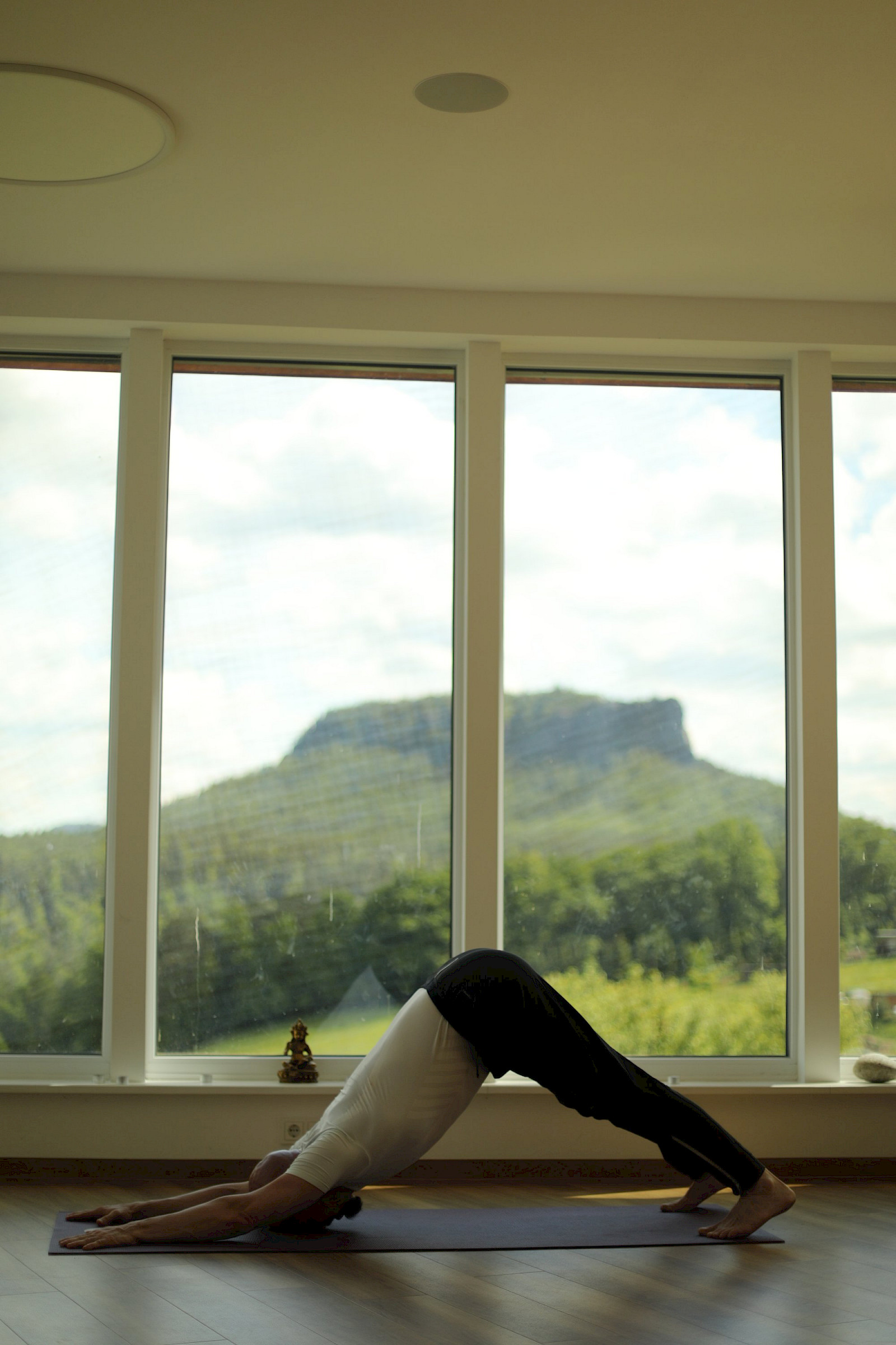 Yoga-Silhouette vor Panoramafenster